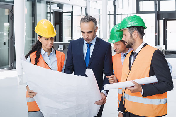Businessman discussing on blueprint with architects in office building